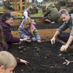 Economics professor John Abell helps local citizens create a community garden at nearby New Vistas School. Economics professor John Abell helps local citizens create a community garden at nearby New Vistas School.