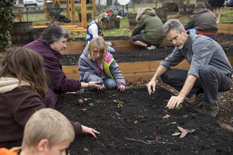 Economics professor John Abell helps local citizens create a community garden at nearby New Vistas School. Economics professor John Abell helps local citizens create a community garden at nearby New Vistas School.