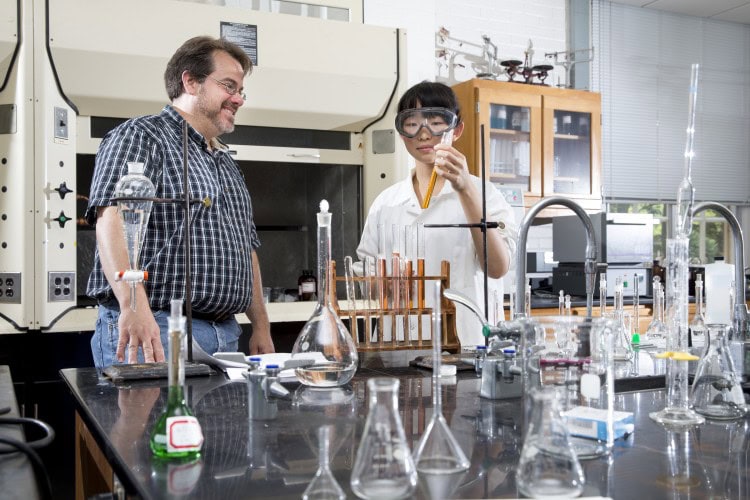 Chemistry professor Bill Bare looks at colored solutions prepared by Di Bei '18 that may be used to test water contamination levels.