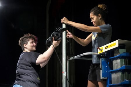 Daisy Howard ’17 (left) and Morgan Wardlaw ’17 hang lights in Thoresen Theatre.