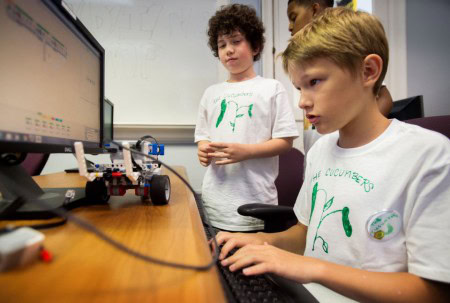 Irvin Putney codes his lego robot to test in a tiral run on the course at Tech Cats Coding Camp on Wednesday at Randolph College. (Photo by Jill Nance)