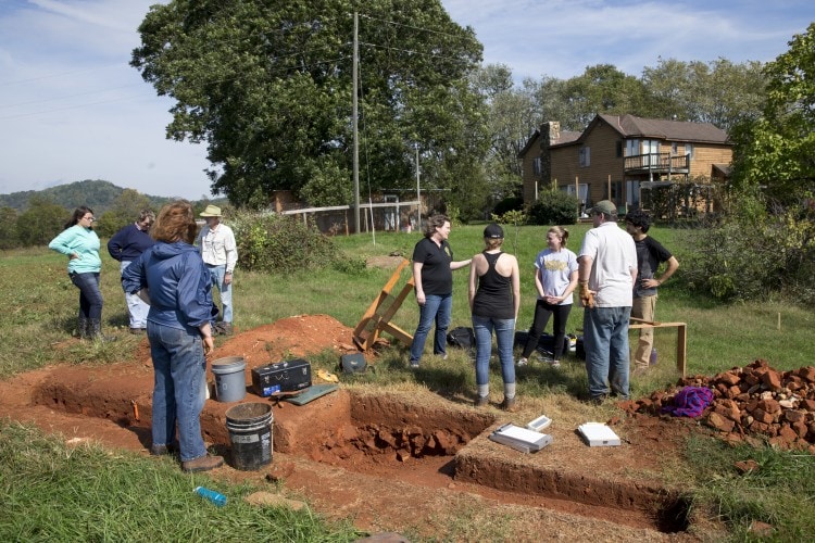 Professor Sarah Sojka, Sara Woodward '16, and Hagay Haut '16 speak with other volunteers in the archaeology project at the site of the uncovered jailhouse.