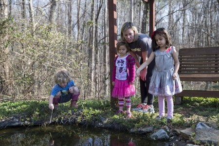 Carrie McCane '16 and RCNS students track the progress of tadpoles living in the pond.