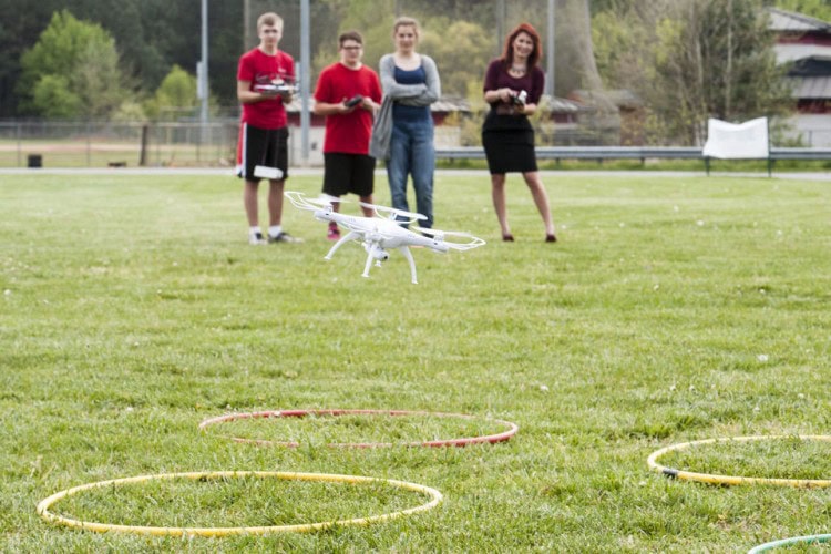 L-R: Keaton Ellis, James Dodson, Olivia Moore, and teacher Caitlin Unterman practice flying and landing a drone during coursework on a mock mission to Mars in Ms. Unterman's 8th grade science class on Thursday, April 21, 2016 in Forest, Va. The students are planning a simulated mission to Mars and are even getting help from NASA scientists. (Photo by Jay Westcott/The News & Advance)