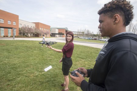 Dyson Yuille, 14, prepares to fly a drone that is carrying a simulated sky crane, which teacher Caitlin Unterman is holding, during coursework on a mock mission to Mars on Thursday, April 21, 2016 in Forest, Va. The students are planning a simulated mission to Mars and are even getting help from NASA scientists. (Photo by Jay Westcott/The News & Advance)