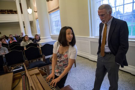 Music professor Emily Yap Chua tests a fortepiano with keynote speaker Nicholas Giordano.