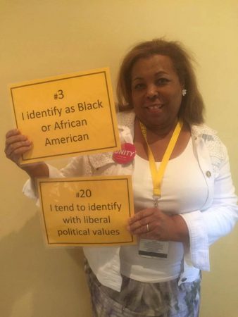 Hermina Hendricks, director of Multi-Cultural Services and instructor in music, holds signs that represent her.