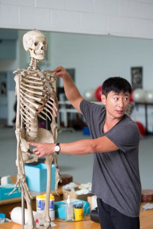 Visiting dance professor Seyong Kim demonstrates how dance motions affect different parts of the human body.