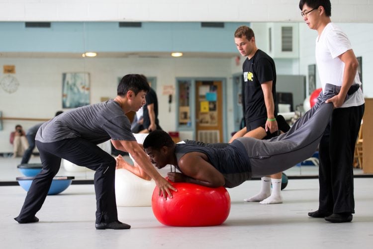 Visiting dance professor Seyong Kim works out with students in Men's Movement class.