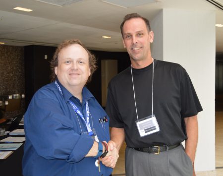 Randolph economics and business professor Jeffery Heinfeldt (right) shakes hands with Timothy Michael, executive director of the Financial Education Association.