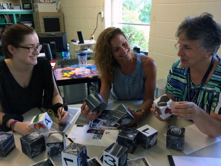 Jasmine Fowler '20 shows the "Curiosity Kit" to New Vistas School teachers Susan Royer '17 M.A.T. and Diane Roy.