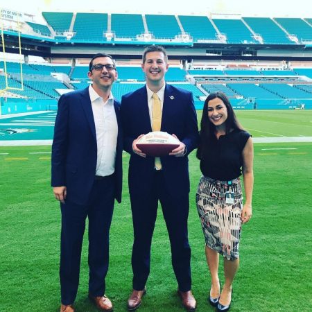 Mitch MacDonald '17 (center) at Hard Rock Stadium, home of the Miami Dolphins. He was recently promoted to a business development account executive for the organization.