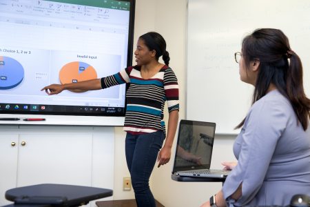 Taylor Samuels '18 and mathematics professor Jia Wan compare data about first-year seminar choices.