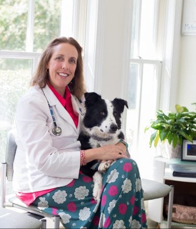 Leslie Jones '93 poses with Dugan, her 3-year-old rescued Border Collie, at her veterinary practice in Midlothian, Virginia.