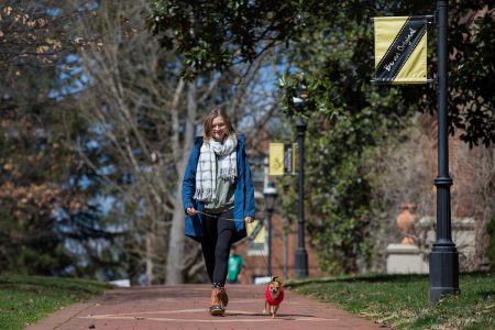 Lydia Edwards '19 walking a dog on front campus