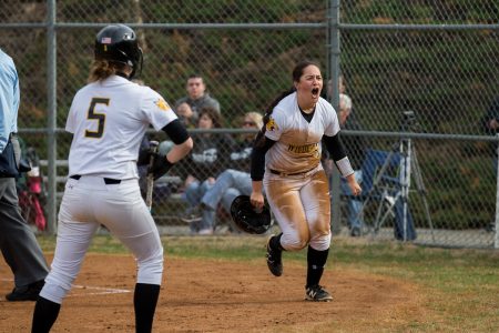 A softball player celebrates near home plate