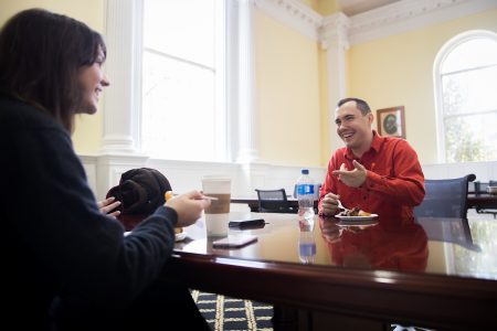 A female and male student sitting a table in the library, eating pie