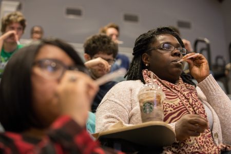 Students hold straws to their mouths in a Science Festival workshop on vocals and acoustics, led by Nicholas Perna.