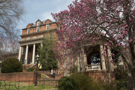 The engagement tower, with a blooming tree in the foreground and Moore Hall in the background