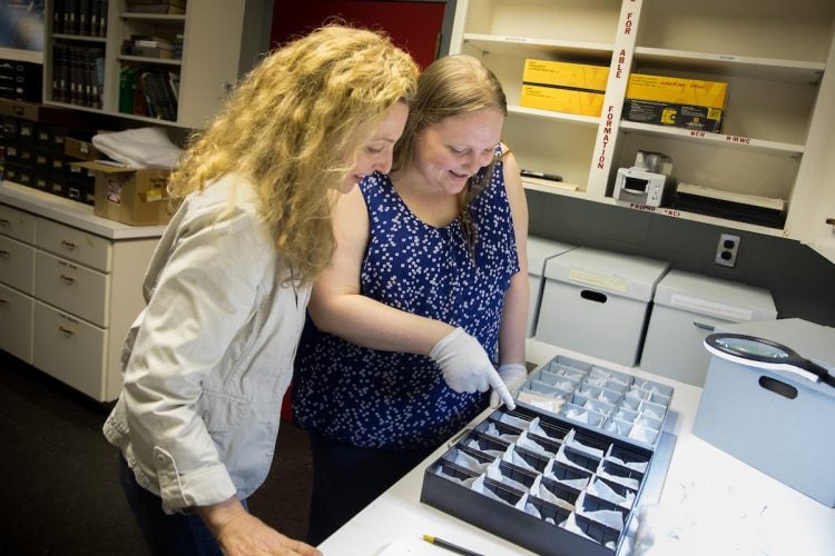 Art history professor Andrea Campbell and Sara Primm '20 look at glass samples from Randolph's archaeology collection