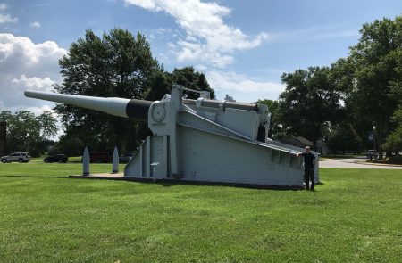 Alex Clem '19 stands next to a cannon used on a ship in WWII.