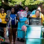 Move-in volunteers and new students push luggage carts along the Red Brick Path Move-in volunteers and new students push luggage carts along the Red Brick Path