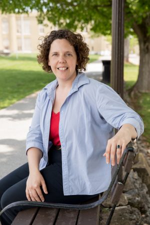 Laura "Beth" Hunt ’00 sits on a bench at Virginia Military Institute, where she works as a first sergeant for the campus police department.