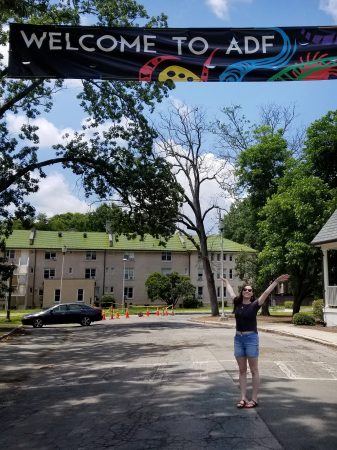 Katie Reep '19 in front of a sign welcoming American Dance Festival participants