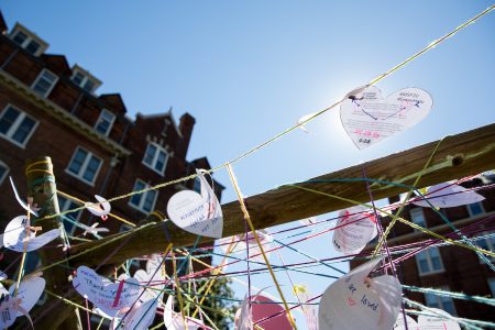 Students wrote heart-shaped messages on a fence in Bell Quad as part of the commemorative service for Matthew Shepard.