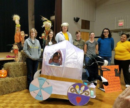 Randolph students pose with Maddie, age 6, in her Cinderella-themed costume, "Maddierella"