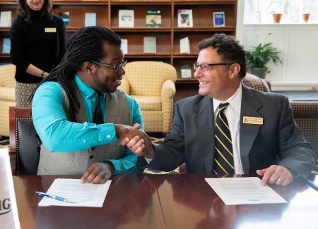 Nick George, founder and executive director of The Listening, and Carl Girelli, vice president for academic affairs and dean of Randolph College, shake hands following the announcement of the new partnership. 