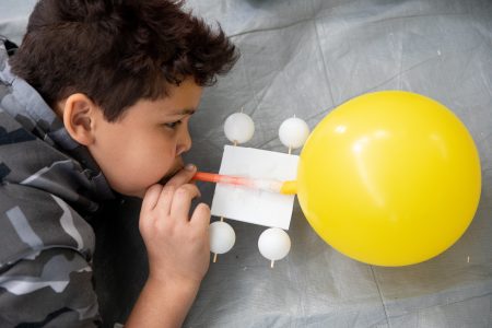 Students blow up balloons for a propelled car at Science Festival.