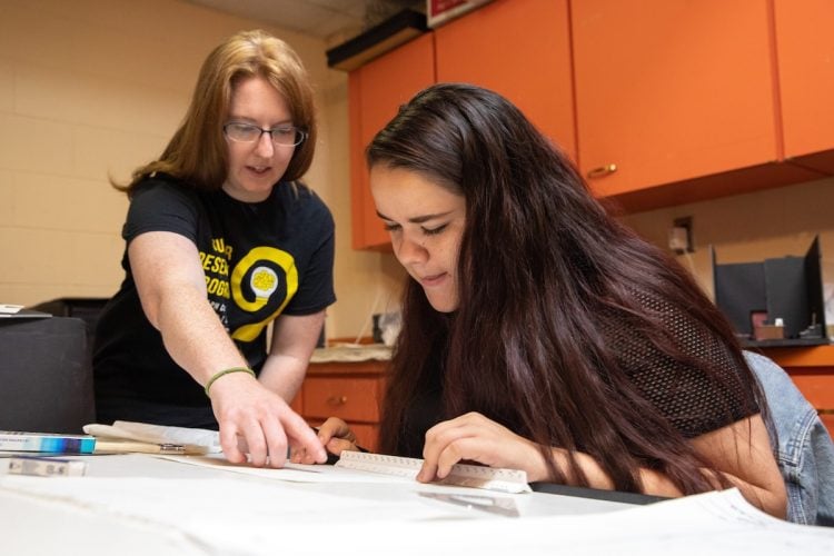 Professor Heather Sinclair (left) and Karyn Heisig draw stage renderings