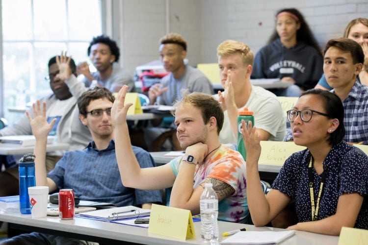 Students in the 2018 SUPER program raise their hands during a classroom activity