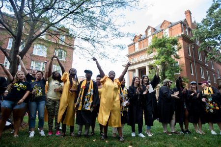 Students sing school songs by the Sundial