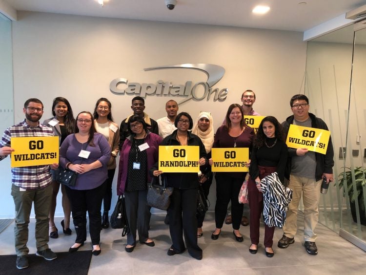 Students and Capital One staff pose with signs that read, "Go WildCats!"