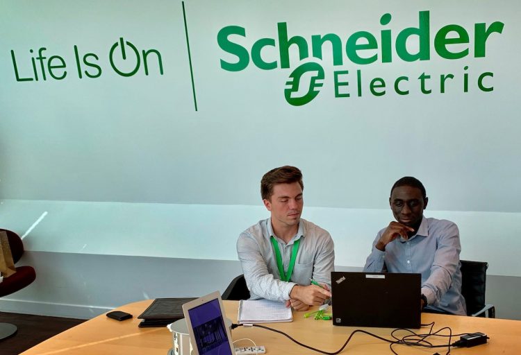 Anthony Fonnesu works with a colleague at Schneider Electric