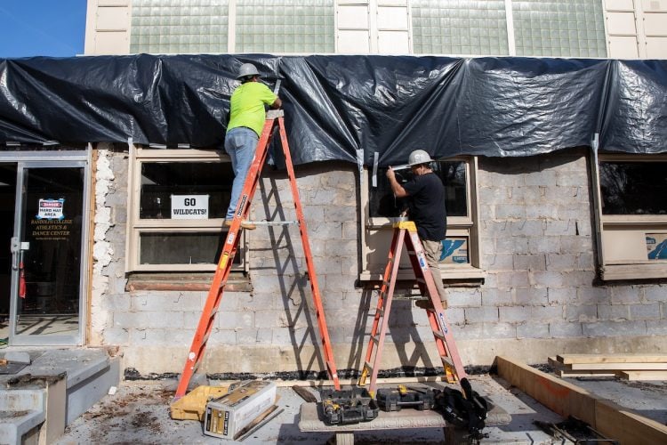 Construction workers make improvements to the exterior of the athletics center