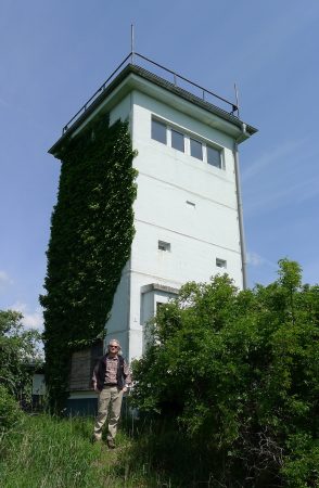 Randolph philosophy professor David Schwartz poses in front of a defunct East German watchtower used during the Cold War. 