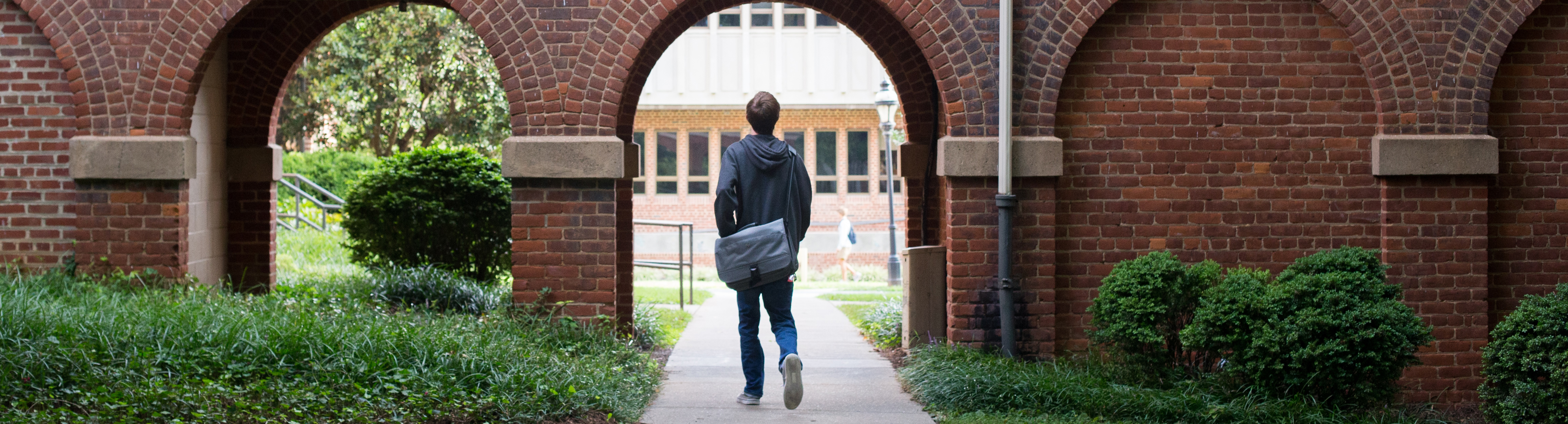 Photo of student walking through campus.