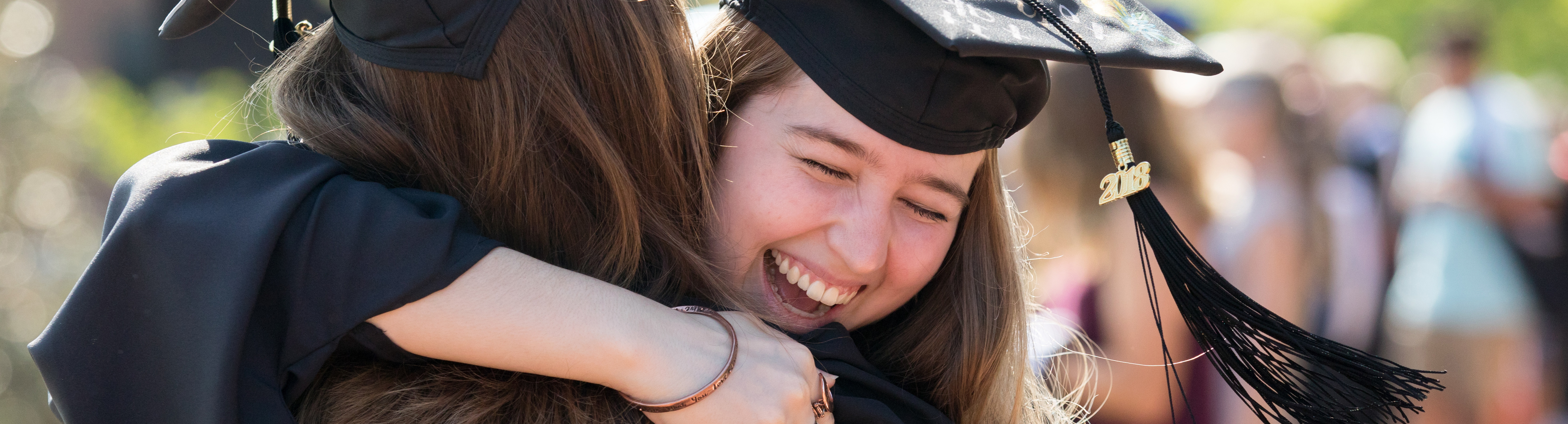 Students hugging at graduation.