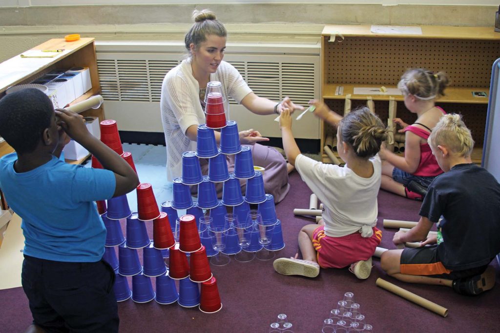 Student teacher builds towers with schoolchildren.