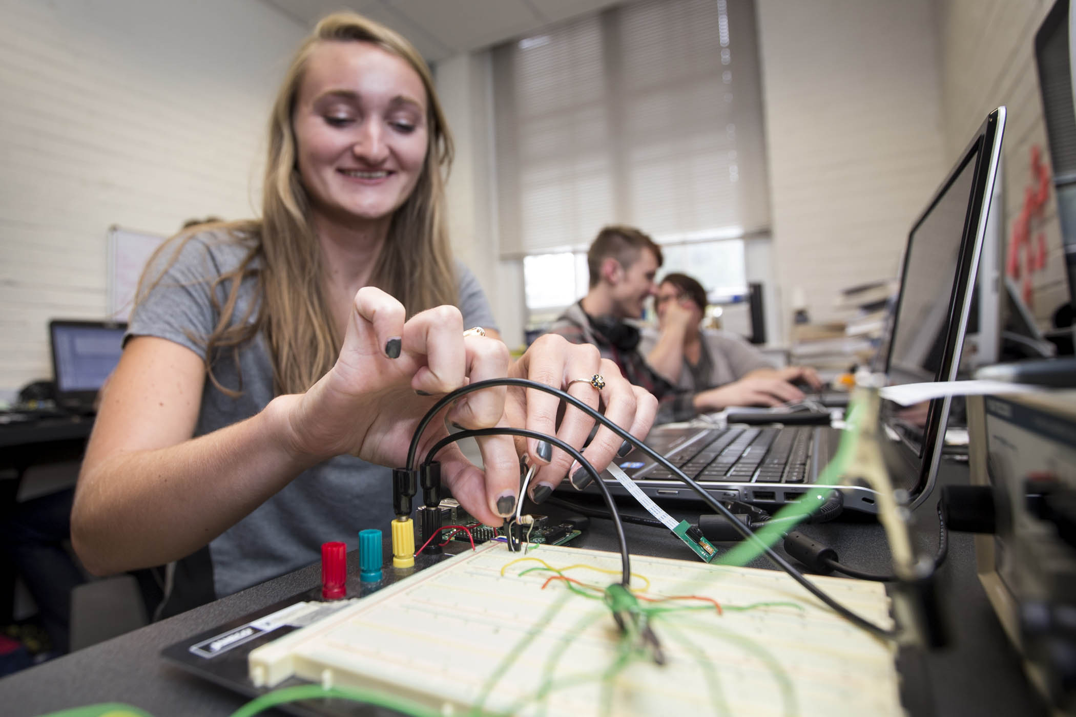 Student checks electrical connections on instruments