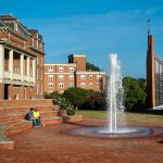Two students watch the sun rise in Michels Plaza outside the Randolph College student center.