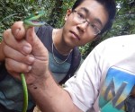 Photo of student looking at snake Photo of student looking at snake