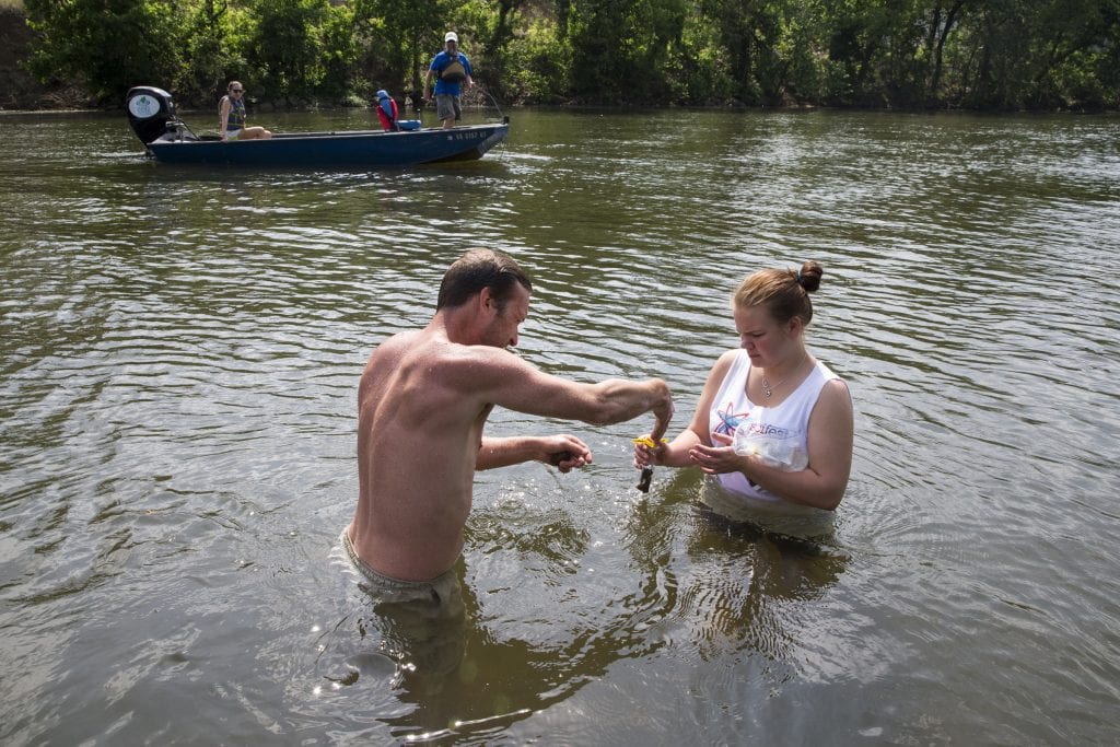 Allison Brooks '18 and Rob Campbell '13 collect soil samples by hand while Melissa Pasierb '17 and River Keeper Pat Calvert test other sites from a motorboat.