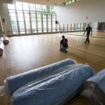 Workers prepare to install the new padded vinyl floor in the dance studio at Randolph College.