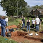 Professor Sarah Sojka, Sara Woodward '16, and Hagay Haut '16 speak with other volunteers in the archaeology project at the site of the uncovered jailhouse.