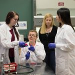 (From left) Jessica Sidebottom '17, Callan Frye '17, and Di Bei '18 examine a sample as biology professor Amanda Rumore observes.