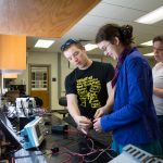 Sarah Sojka, physics and environmental studies professor, observes as Zach Vernon '18 and Leonora Bratvold-Boyd '19 conduct a lab test.